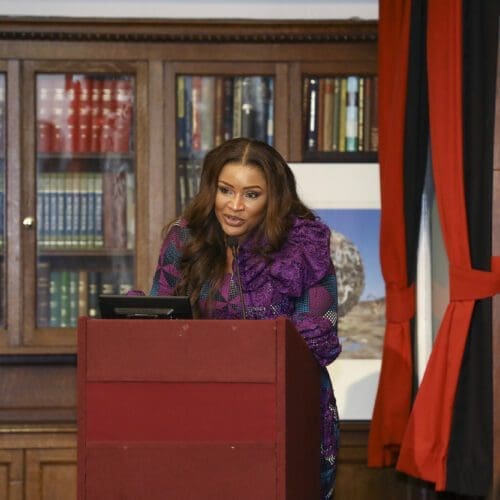 A woman stands at a podium and talks.