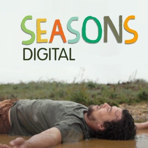 Seasons Digital in colourful writing with man laying in mud underneath