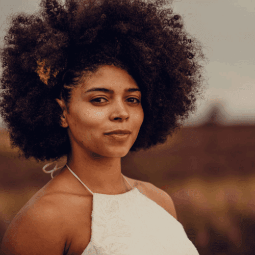 A young mixed race woman with an afro wearing a white top
